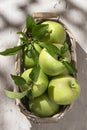 Granny Smith apples in basket. Fresh green fruit on rustic white background Royalty Free Stock Photo