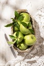 Granny Smith apples in basket. Fresh green fruit on rustic white background Royalty Free Stock Photo