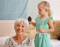 Grannys gonna look good after this. a cute little girl brushing her grandmothers hair.