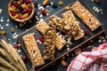 Granola bar with nuts, fruit and berries on black. Royalty Free Stock Photo