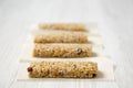 Granola bars on baking sheet over white wooden surface, side view. Close-up. Selective focus Royalty Free Stock Photo