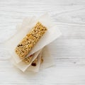 Granola bars on baking sheet over white wooden surface, view from above. Flat lay Royalty Free Stock Photo