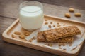 Granola bars and glass of milk on wooden plate Royalty Free Stock Photo