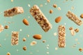 Granola bars and nut clusters floating on green background Royalty Free Stock Photo
