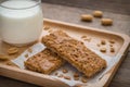 Granola bars on wooden plate and glass of milk Royalty Free Stock Photo