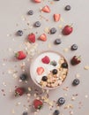 Granola and berries falling into yoghurt