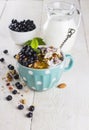 Granola with blueberry, mint, honey and milk in blue bowl with m Royalty Free Stock Photo