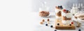 Granola, cereal breakfast banner. Blueberry parfait in glasses on wooden board on gray background. Cafe, restaurant, confectionery
