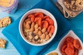 Granola cereal flakes with dried fruit, nuts in green bowl on blue wooden table. Top view. Royalty Free Stock Photo