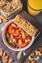 Granola cereal flakes with dried fruit, nuts in green bowl on gray wooden table. Top view. Royalty Free Stock Photo