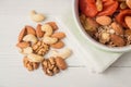 Granola cereal flakes with dried fruit, nuts in green bowl on white wooden table. Top view. Royalty Free Stock Photo