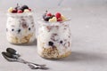 Granola crispy honey muesli with frozen berries, cottage cheese and natural yogurt in two glass jars on gray background Royalty Free Stock Photo