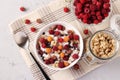 Granola crispy with natural yogurt, fresh red and yellow raspberries, chocolate and nuts in a bowl on gray background Royalty Free Stock Photo