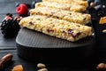 Granola energy bars with nuts, seeds, berries, on black wooden table Royalty Free Stock Photo