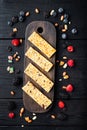 Granola energy bars with nuts, seeds, berries, top view, on black wooden table Royalty Free Stock Photo