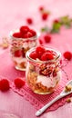 Granola with fresh raspberries and natural yogurt in a glass jar on a wooden pink table. Delicious breakfast or dessert. Royalty Free Stock Photo