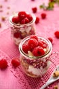 Granola with fresh raspberries and natural yogurt in a glass jar on a wooden pink table. Delicious breakfast or dessert. Royalty Free Stock Photo