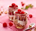 Granola with fresh raspberries and natural yogurt in a glass jar on a wooden pink table. Delicious breakfast or dessert. Royalty Free Stock Photo