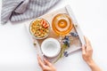 Granola with fruit, cup and tea for breakfast in bed in hands on white background top view Royalty Free Stock Photo