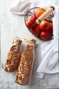 Granola in glass bottles on a light background. Red apples in a metal basket. Muesli in glass bottles. Healthy low-calorie food.