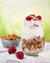 Granola with greek yogurt parfait fresh raspberries, coconut in a glass on wooden table outdoors. Healthy, tasty summer breakfast Royalty Free Stock Photo