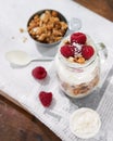 Granola with greek yogurt parfait fresh raspberries, coconut in a glass on wooden table outdoors. Healthy, tasty summer breakfast Royalty Free Stock Photo
