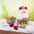 Granola with greek yogurt parfait fresh raspberries, coconut in a glass on wooden table outdoors. Healthy, tasty summer breakfast Royalty Free Stock Photo