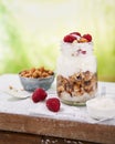 Granola with greek yogurt parfait fresh raspberries, coconut in a glass on wooden table outdoors. Healthy, tasty summer breakfast Royalty Free Stock Photo