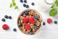 Granola muesli, milk and ripe blueberries and raspberries, healthy breakfast concept, wooden background, top view Royalty Free Stock Photo