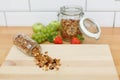 Granola scattered from a glass bottle on a wooden table