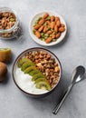 Granola with yogurt, banana and kiwi in a bowl on a light background