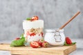 Granola or yogurt with strawberry in glass, fresh berries and jar with sugar on a cutting board Royalty Free Stock Photo