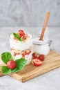 granola or yogurt with strawberry in glass, fresh berries and jar with sugar on a cutting board, top view Royalty Free Stock Photo