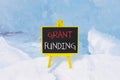 Grant funding symbol. Concept words Grant funding on beautiful yellow black blackboard. Beautiful blue ice background. Business Royalty Free Stock Photo