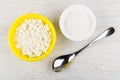 Granular cottage cheese in bowl, sugar in bowl, spoon Royalty Free Stock Photo