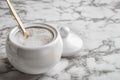 Granulated sugar in bowl on marble table. Space for text