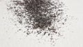 Granules of black material spread out on a smooth white surface, showcasing unique textures and patterns for artistic exploration Royalty Free Stock Photo