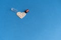 Granules poured from a heart-shaped capsule on a classic blue background. Heart shaped medicines. Heart symbol drawn by pills Royalty Free Stock Photo