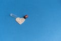Granules poured from a heart-shaped capsule on a classic blue background. Heart shaped medicines. Heart symbol drawn by Royalty Free Stock Photo