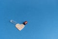 Granules poured from a heart-shaped capsule on a classic blue background. Heart shaped medicines. Heart symbol drawn by Royalty Free Stock Photo