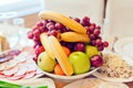 Grape, apples, pears, bananas and other fruits in a vase on a festive table