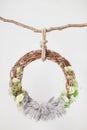A grape cradle ring hanging on a rope on a stick, decorated with green flowers and leaves with a gray wool rug Royalty Free Stock Photo