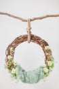 A grape cradle ring hanging on a rope on a stick, decorated with green flowers and leaves with a green wool rug Royalty Free Stock Photo