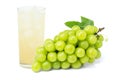 Glass of grape juice and bunch of white grapes with leaf.