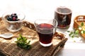 Grape juice poured into a glass on a rattan tray