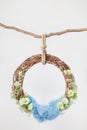 Grape ring cradle for newborns on a white background, decorated with green flowers eustomas with a blue rug