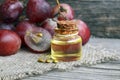 Grape seed oil in a glass jar and fresh grapes on old wooden table.Bottle of organic grape seed oil for spa and bodycare. Royalty Free Stock Photo