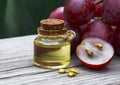 Grape seed oil in a glass jar and fresh grapes on old wooden table. Bottle of organic grape seed oil for spa and bodycare. Royalty Free Stock Photo