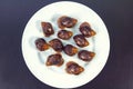 Grape snails, akhatina, on a plate, as crude food, a rawism Royalty Free Stock Photo