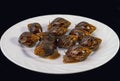 Grape snails, akhatina, on a plate, as crude food, a rawism Royalty Free Stock Photo